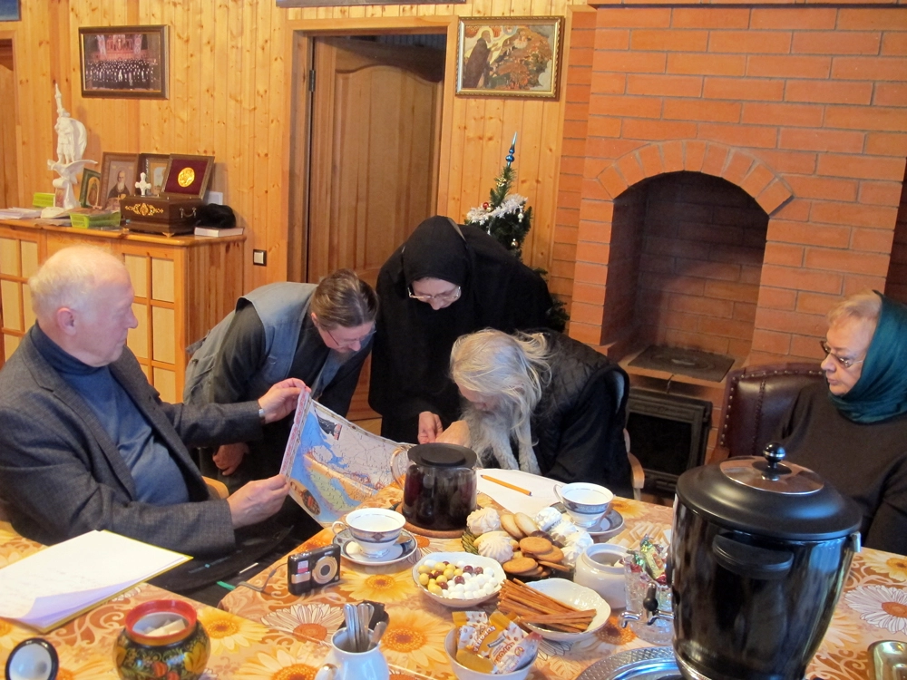 Старец Илий изучает карту времен Великой Отечественной войны.