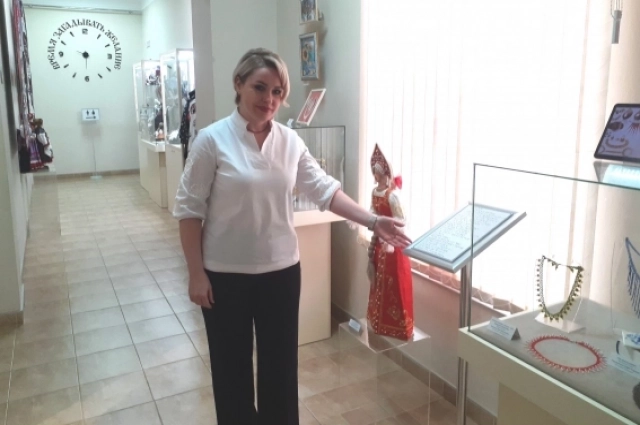 Анна Ильина показывает тактильные таблички со шрифтом Брайля, которые и после выставки останутся в основной экспозиции музея.