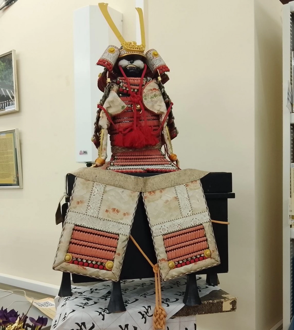 Доспехи самурая стоят на специальной коробке из чëрного лака в которой они должны традиционно храниться.