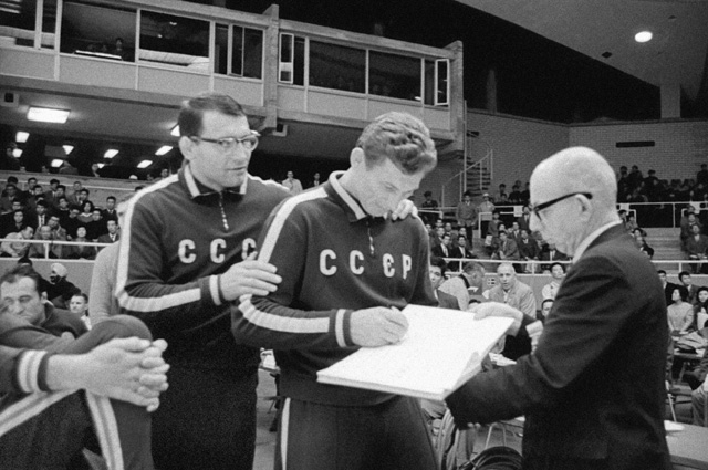 Чемпионы ХVIII летних Олимпийских Игр по вольной борьбе Александр Иваницкий /первый слева/ и Александр Медведь дают первые автографы.