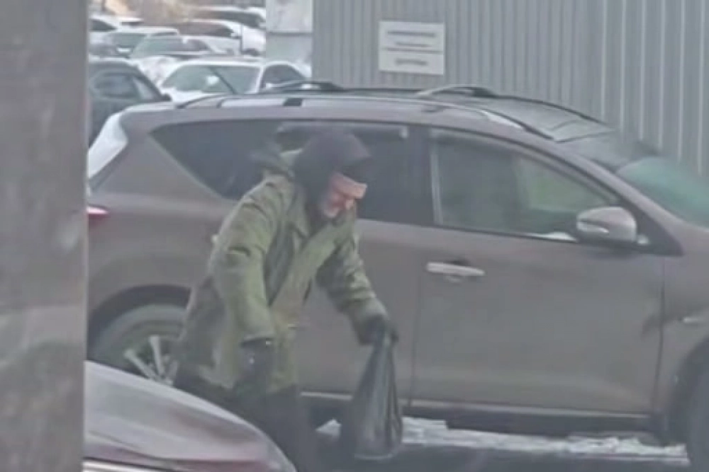 Пенсионер пытается вынести мусор, но его буквально сдувает ураганом.