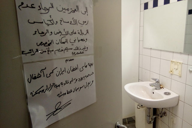 Надпись арабской вязью на двери туалета.