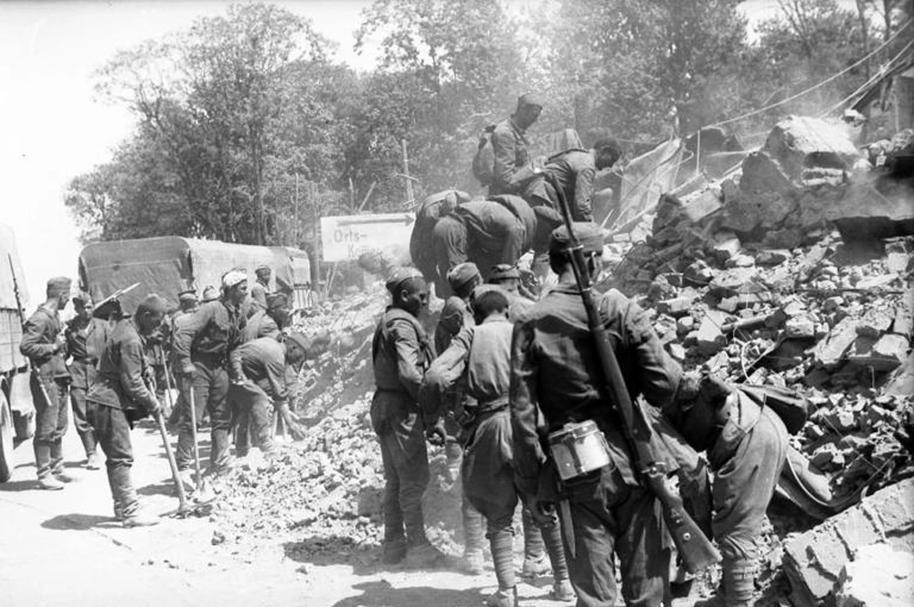 Советские военнопленные расчищают завалы разрушенных домов.