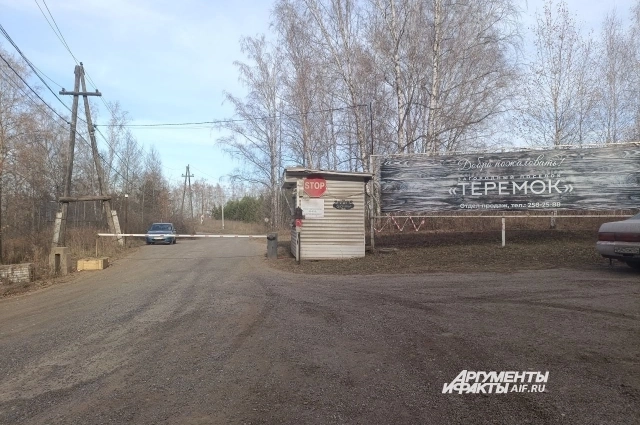 На въезде в поселок - шлагбаум.