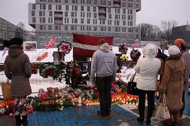 Жители Риги возлагают цветы и зажигают свечи в память о погибших год назад в результате обрушения крыши у торгового центра Maxima. 2014 г.