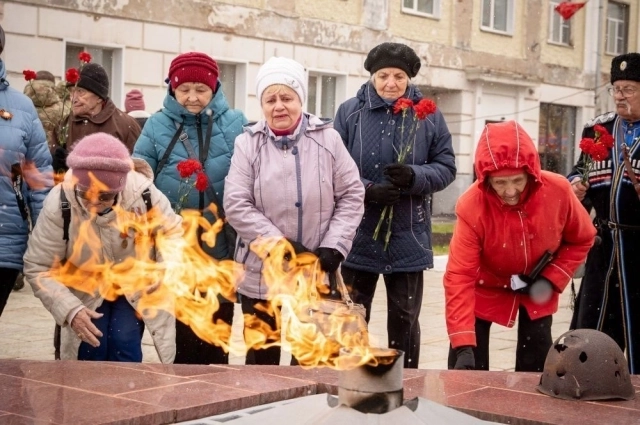 Люди выстаивали длинные очереди, чтобы возложить цветы к мемориалу.