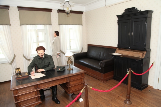 В музее есть фигура Льва Троцкого. Он занёс перо над письмом.