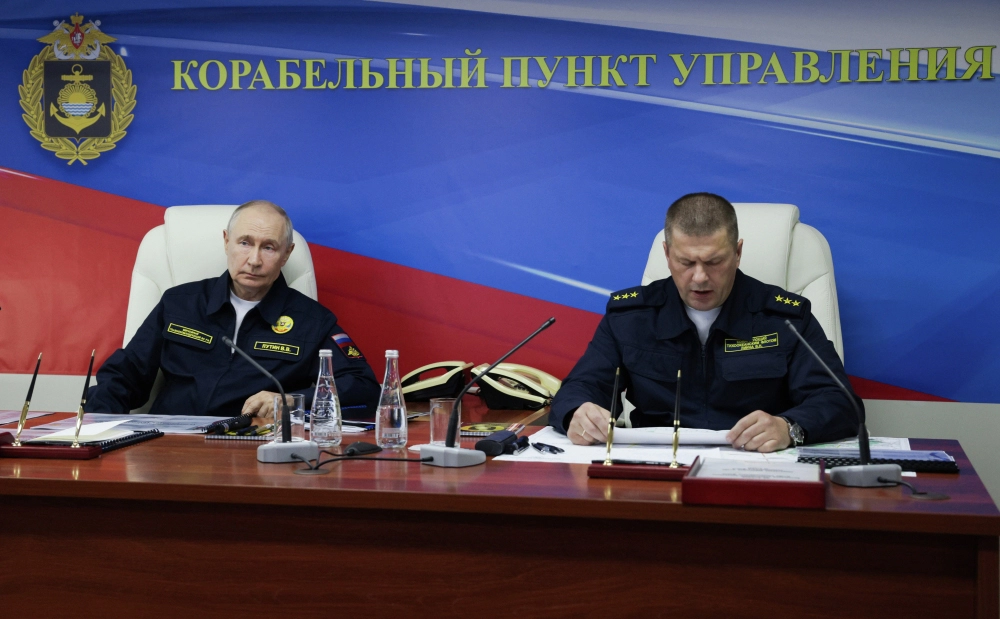 Президент России Владимир Путин проводит совещание на ракетном крейсере «Варяг» во время завершающей стадии учений Тихоокеанского флота. Справа — командующий Тихоокеанским флотом Военно-Морского Флота Российской Федерации адмирал Виктор Лиина.