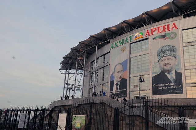 Фасад стадиона украшают огромные цветные фотографии Владимира Путина и Ахмата Кадырова