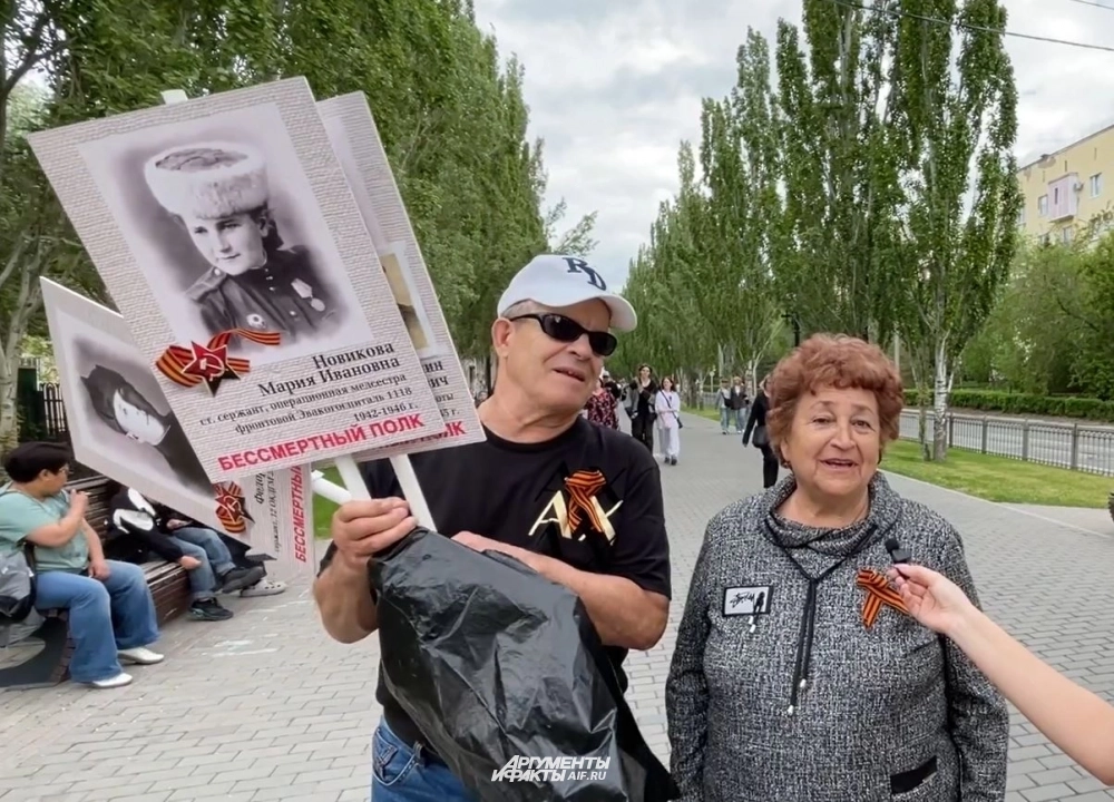 Лариса Дашина со портретами своих родных и с мужем.