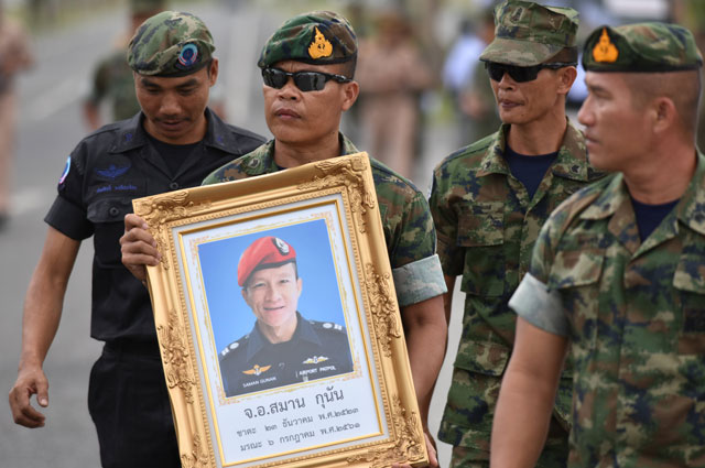 Военные держат портрет погибшего спасателя.
