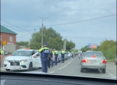 Полицейские досматривают машины.