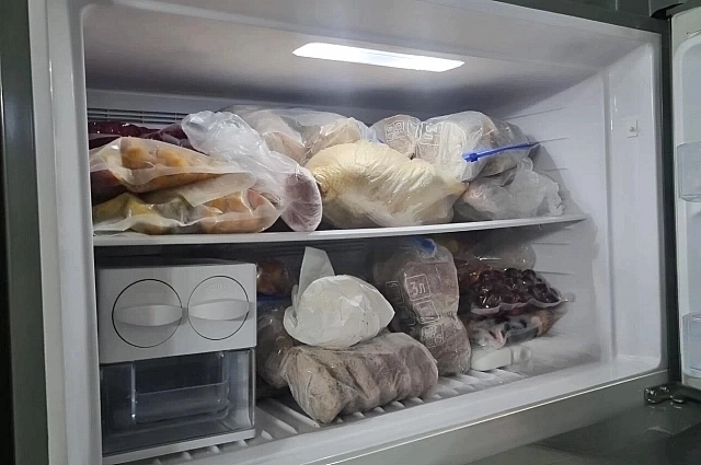 В морозильнике на полках психиатра Ольги Бухановской ягоды и фрукты с дачи, расфасованные по пакетам, замороженная куриная тушка, мясные заготовки, мясные котлеты из дичи, замороженная вишня.