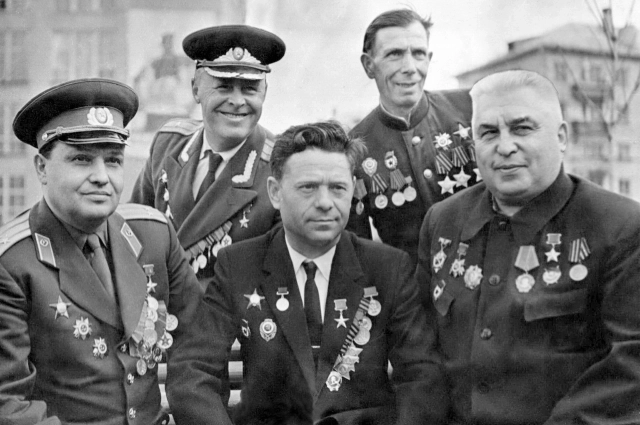 Сидят (слева направо): Герой Советского Союза Г. М. Вожакин, полный кавалер орденов Славы С. В. Фёдоров, Герой Советского Союза Н. И. Зиновьев.  За ними стоят Герой Советского Союза М. Я. Подшибякин, полный кавалер орденов Славы А. Я. Свинолупов.