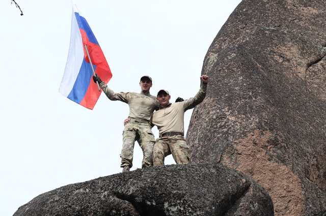 В Красноярске сотрудники полиции в честь праздника водрузили флаг на одну из скал нацпарка «Красноярские столбы». 