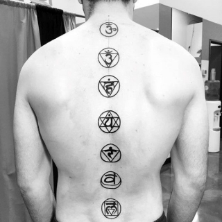 На спине вдоль позвоночника расположена татуировка в виде 6-7 колец 