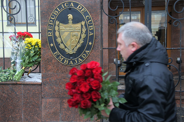 Мужчина несет цветы к посольству Кубы в Москве