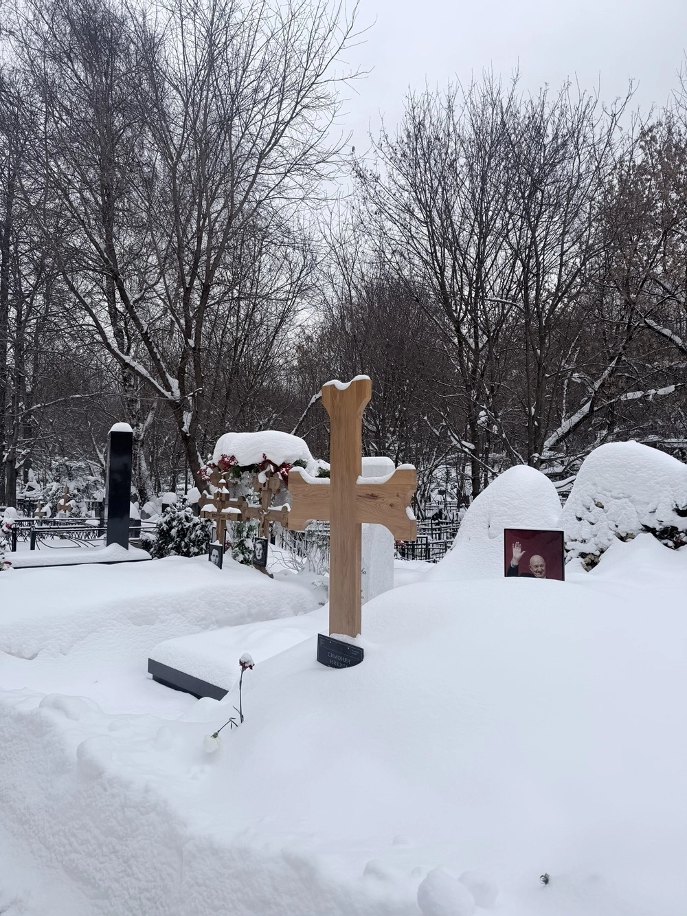 Могилу запорошило снегом.