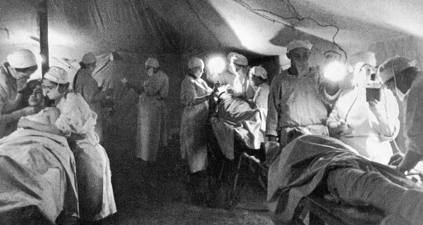 Медицинские работники оперируют бойцов в военно-полевом госпитале