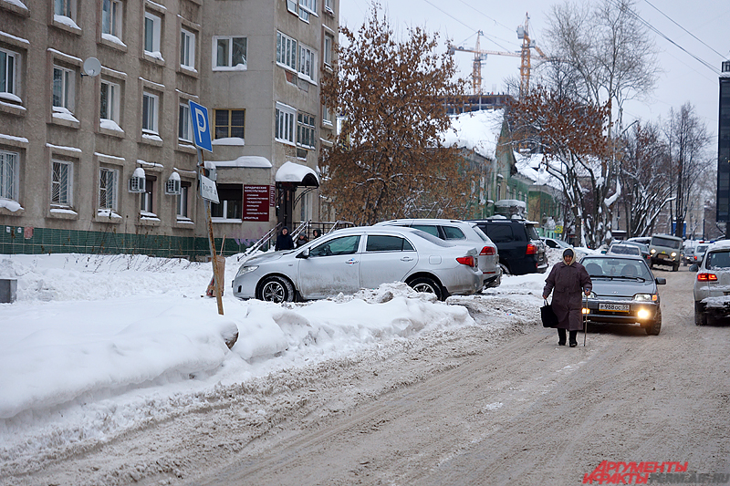 Некоторым пешеходам из-за обилия снега на тротуаре приходится ходить по проезжей части.