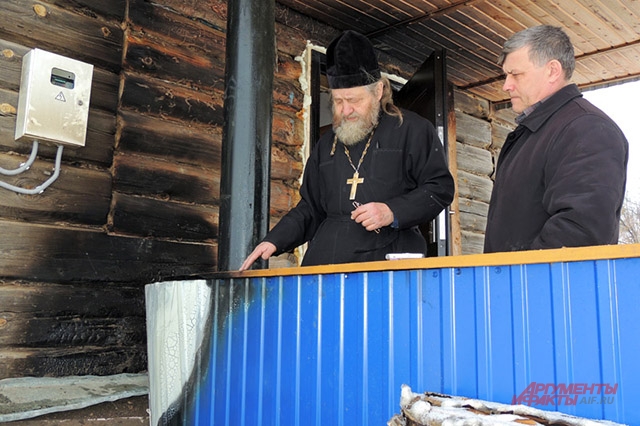 Отец Георгий и глава сельского поселения Ленино показывают место возгорания