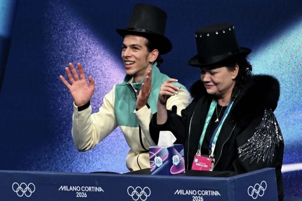 Петр Гуменник, выступающий в нейтральном статусе, после своего выступления с произвольной программой мужского одиночного катания на XXV зимних Олимпийских играх в Милане. Справа: тренер по фигурному катанию Вероника Дайнеко.