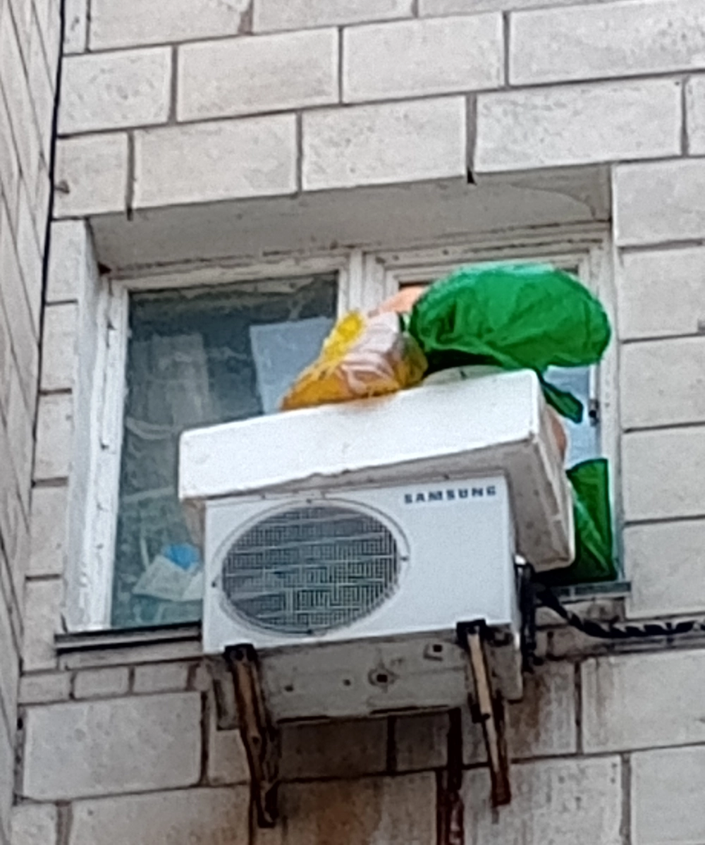 Окно квартиры забито картоном, на улице – большие пакеты.