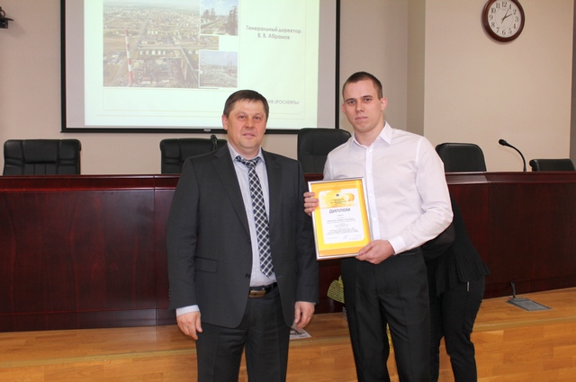 Генеральный директор РНПК Владимир Абрамов вручает заслуженные награды молодым специалистам.