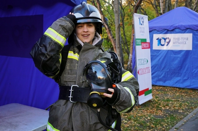 Дети с восторгом примеряют боевую одежду пожарного.