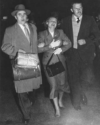 Дипкурьеры Жарков и Карпинский тащат Евдокию Петрову к самолету, 19 апреля 1954 г.