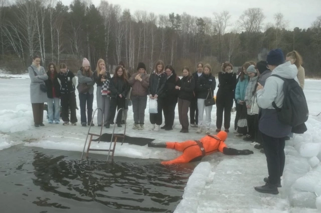 Спасатель ВОСВОД учит людей выбираться из проруби.
