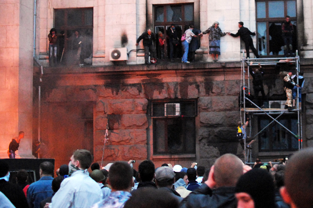 Люди выбираются на карниз здания во время пожара в Доме профсоюзов в Одессе. 2 мая 2014 г.