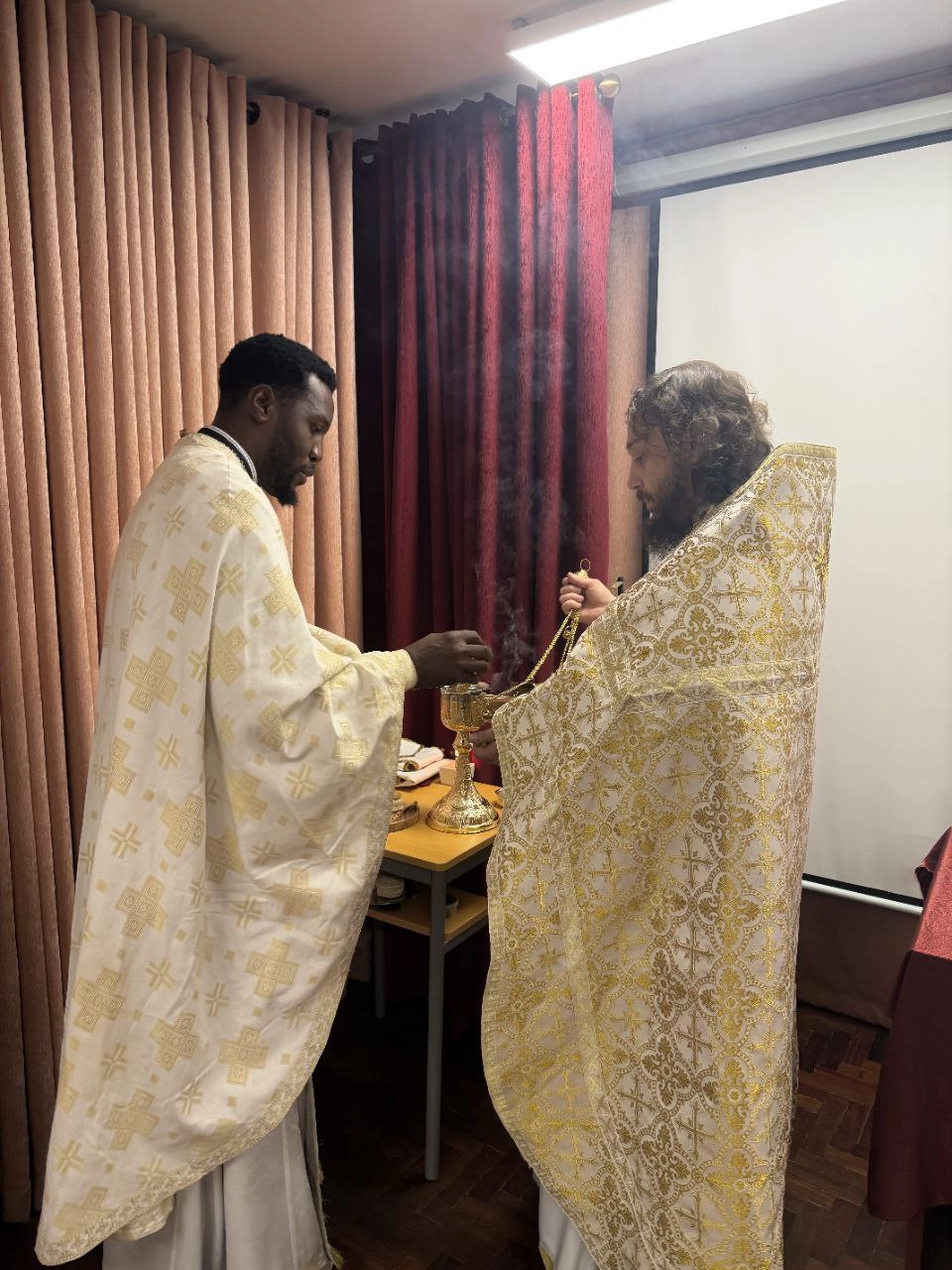 Отец Альвиан и отец Христос на службе на территории российского посольства в Мозамбике.