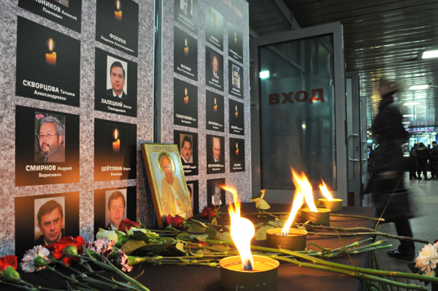 Цветы и свечи у траурной стойки с именами пассажиров, погибших при крушении Невского экспресса в 2009 году, на Ленинградском вокзале