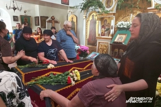Мама Анатолия и Мама Ольги в окружении родственников у гробов своих детей.