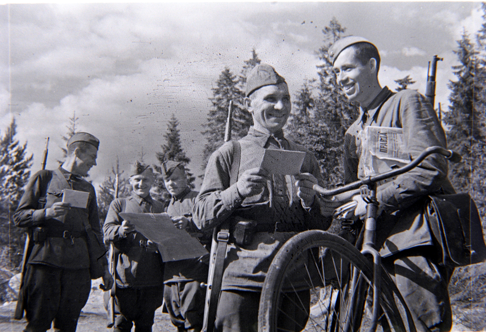 Почтальон ефрейтор А. Сидоренко вручает письма красноармейцам. Ленинградский фронт. 1942 год. 