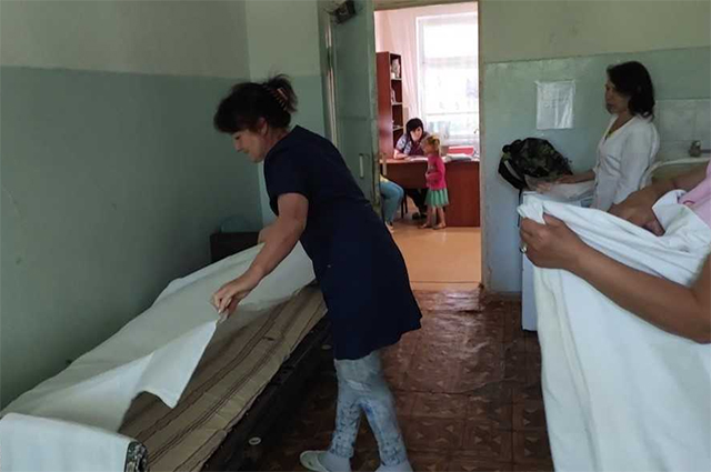 Пока строители работают в соседнем корпусе, в терапии сестрички застилают кровати новым бельем, привезенным волонтерами из Москвы.  