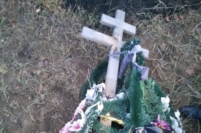 Венки и кресты разбросаны по кладбищу.