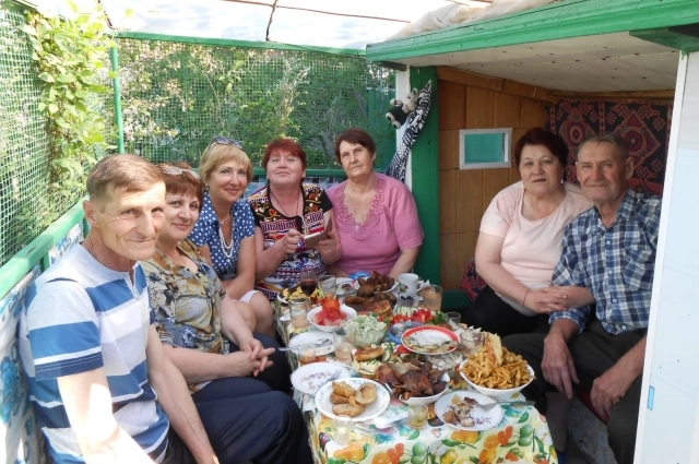 Семейное застолье в беседке перед домом.
