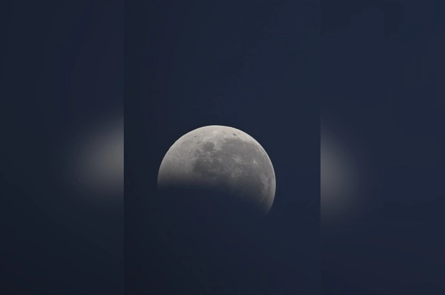 Луна медленно погружалась в тень Земли, меняя свой привычный серебристый цвет на загадочный багрово-красный.