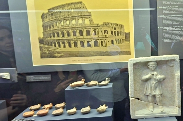 Колизей и мраморный рельеф мальчика с цыпленком.