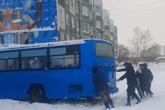 Пассажиры толкают застрявший автобус.