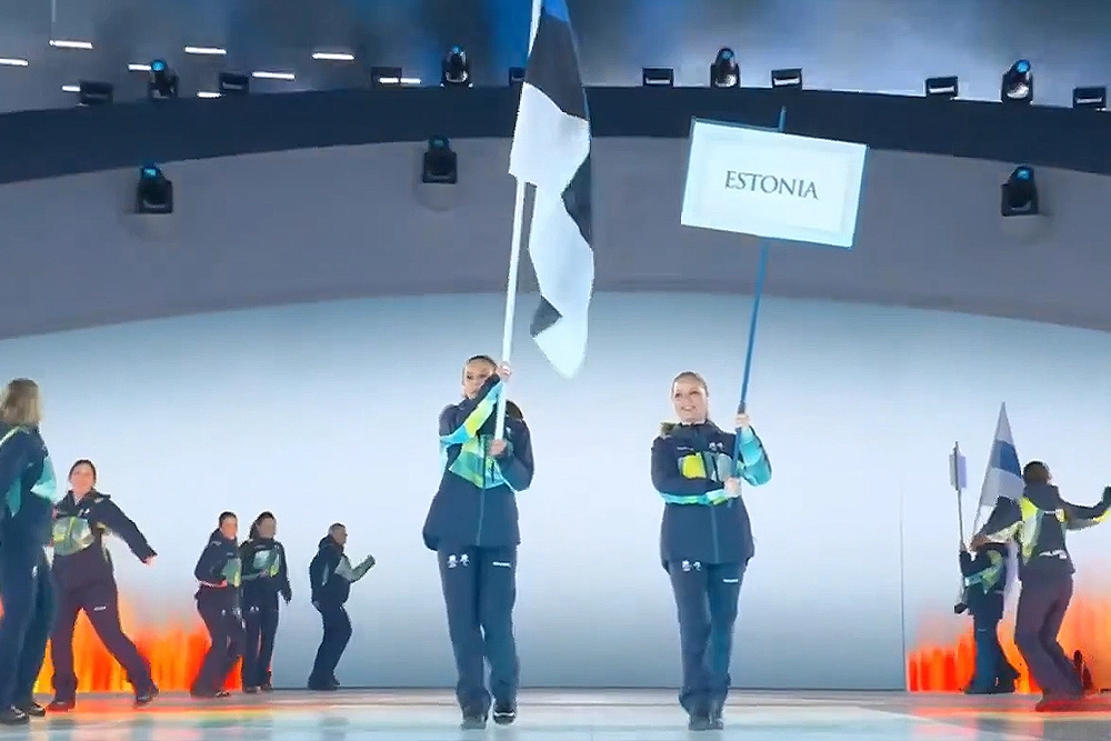 Волонтеры несут флаг Эстонии.