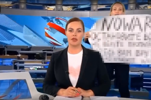 Бывший редактор Первого канала Марина Овсянникова (на заднем плане с плакатом) предала Родину, и теперь нигде не может устроиться - предатели никому не нужны. 