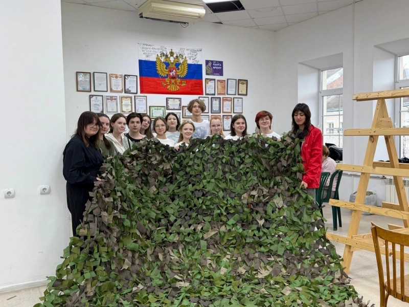 Волонтёры со сплетённой маскировочной сетью.