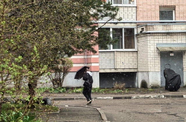 Многие пытались укрыться от метели зонтами.