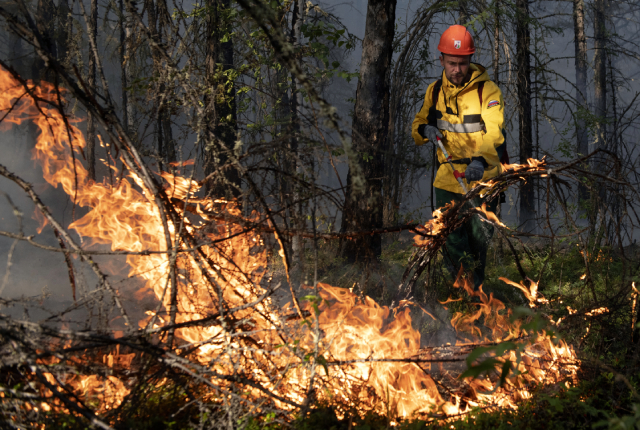 Сотрудник Авиалесоохраны тушит лесной пожар в районе Хангаласский улус в Якутии, 09.08.2021.