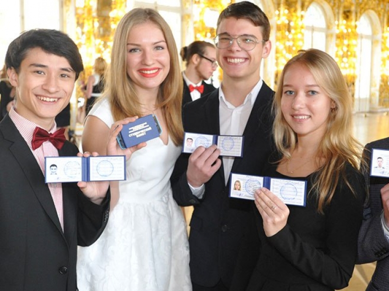На оригинале фото счастливые первокурсники позируют со студенческими билетами.