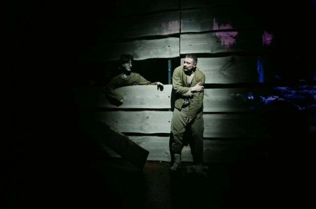 Декорация в спектакле фактически одна. Это большая высокая стена - образ судьбы.