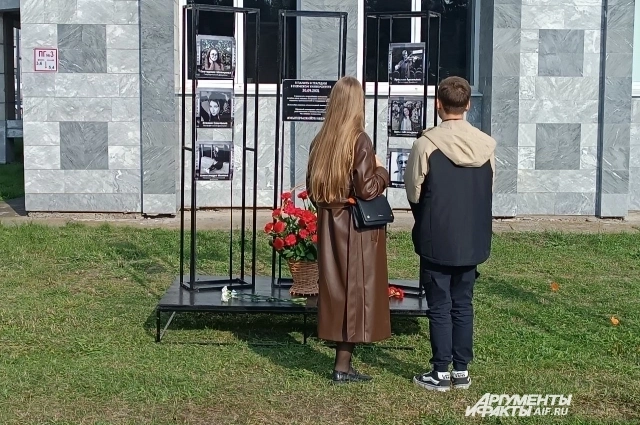 Люди несут цветы в память о жертвах.